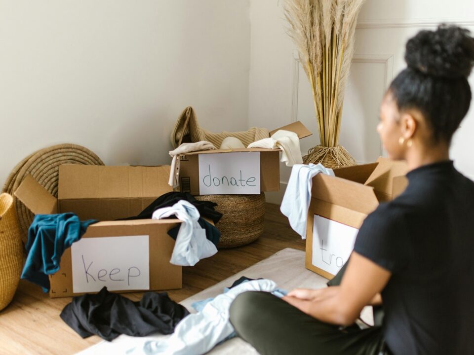 woman sat in front of boxes filled with items to declutter her home
