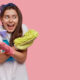 Woman holding cleaning supplies and smiling